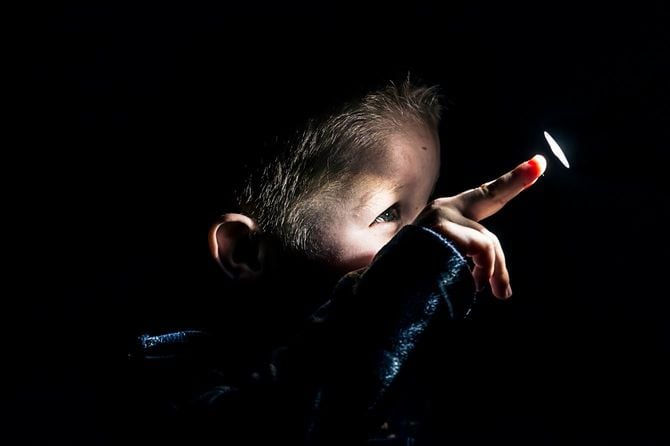 ライトを見つめて、触ろうとしている好奇心旺盛な男児