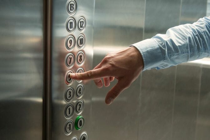 エレベーターの行先ボタンを押す手