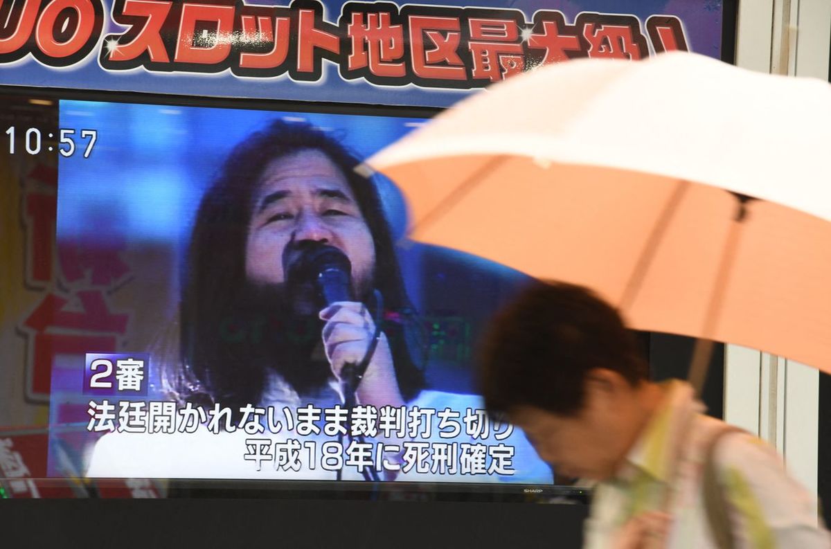 2018年7月6日、オウム真理教の麻原彰晃の死刑執行に関するニュースを報じるスクリーンの前を通り過ぎる歩行者（東京）