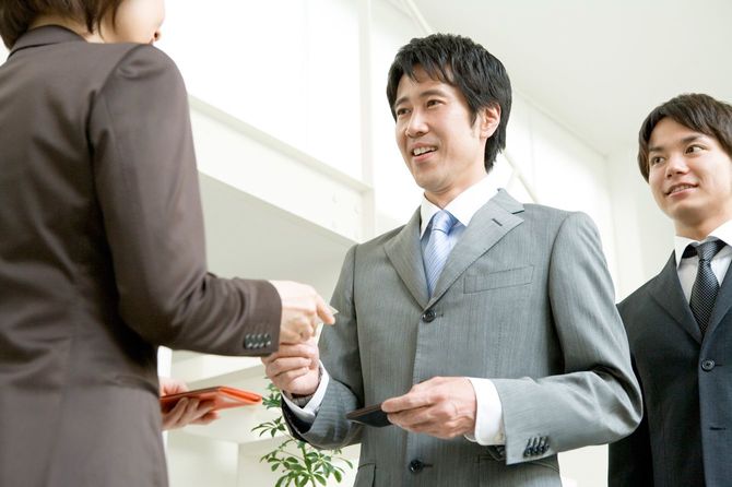 名刺を渡す男