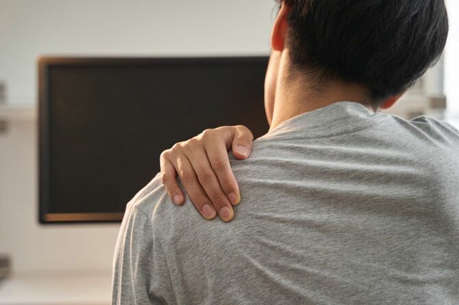 肩に痛みを感じる男性