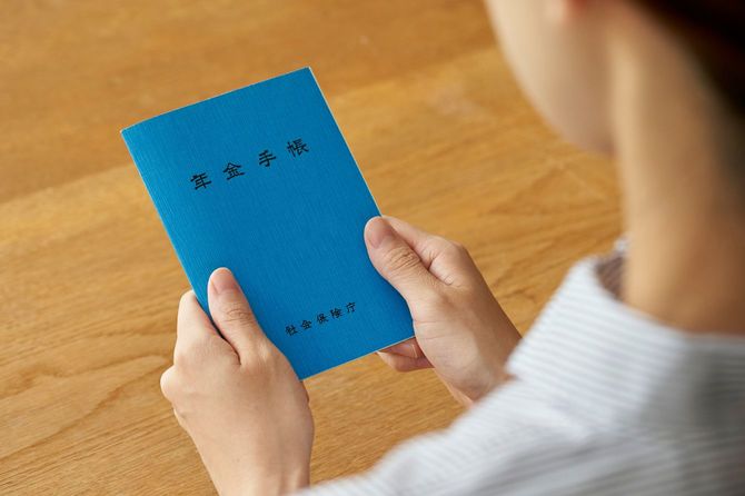 年金手帳を両手で持つ女性
