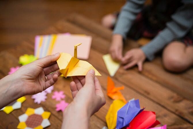 折り紙で遊ぶ親子の手