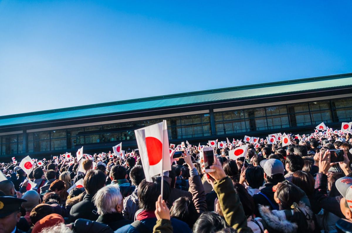 日本国旗を持って1月2日に皇居で天皇を待つ日本の人々