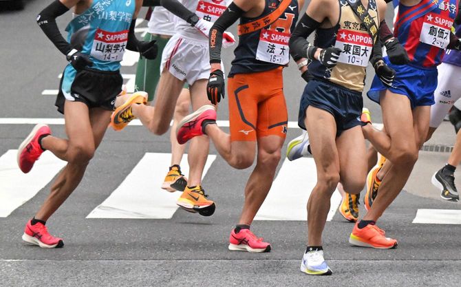 第98回箱根駅伝で、ナイキやアシックスなどのメーカーのシューズを履いてレースに挑む選手たち＝東京都千代田区で2022年1月2日、手塚耕一郎撮影