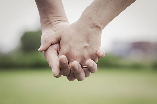 結婚指輪をして手をつなぐ人のイメージ