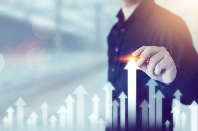 成長する矢印を指で示すビジネスマンのイメージ