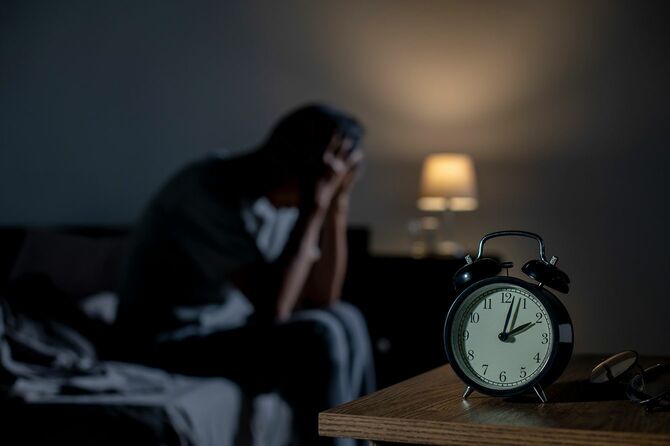 ベッドに座っている不眠症の男性