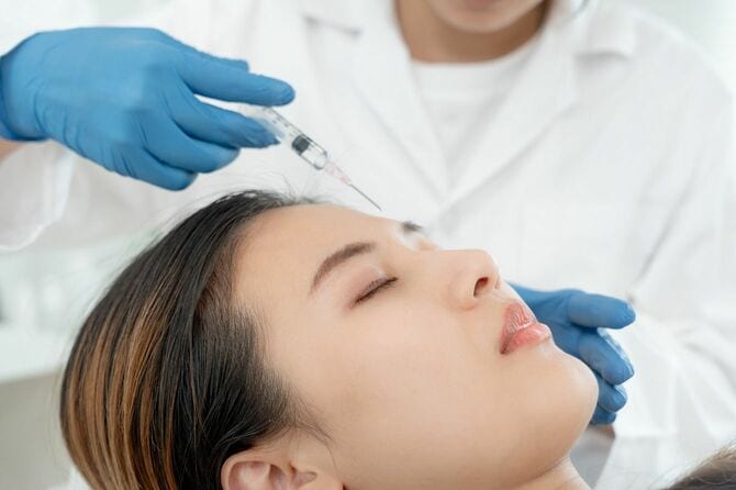 顔に美容外科手術を受ける女性