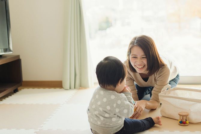 自宅で彼女のかわいい女の子と楽しい時間を過ごしている若いアジアの母親。