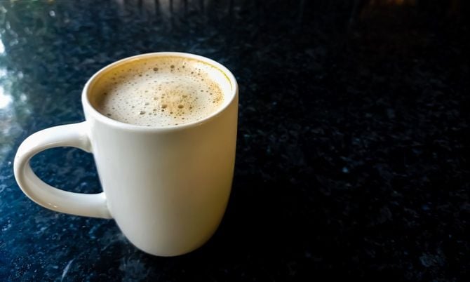 カウンターに置かれたマグカップに入ったカフェオレ