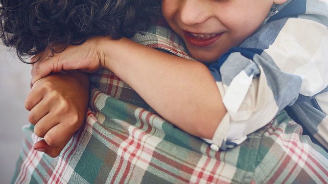 小さな息子を抱きしめる親