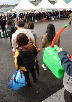 2021年11月09日、韓国南西部の全羅北道益山市にある屋内体育館で、尿素水を買うために列を作って待つ買い物客たち（写真＝EPA／時事通信フォト）