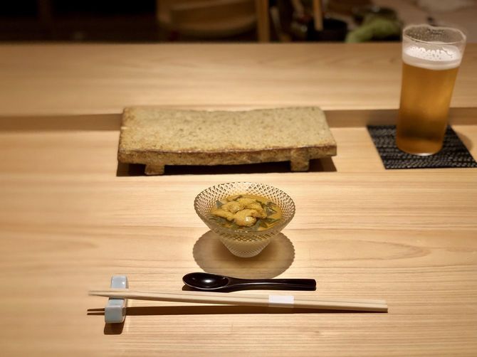 白木のカウンターに置かれた寿司下駄と前菜とビール
