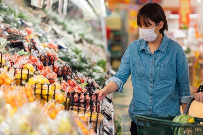 マスクを着用しながらスーパーマーケットで買い物