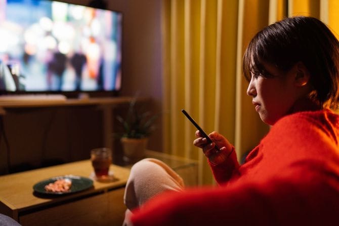 夜に家で映画を見ている若い女性