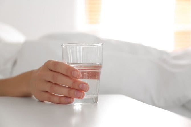 水の入ったコップを持つ女性