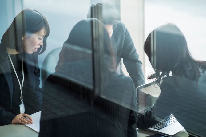 ガラス張りのオフィスでミーティング中