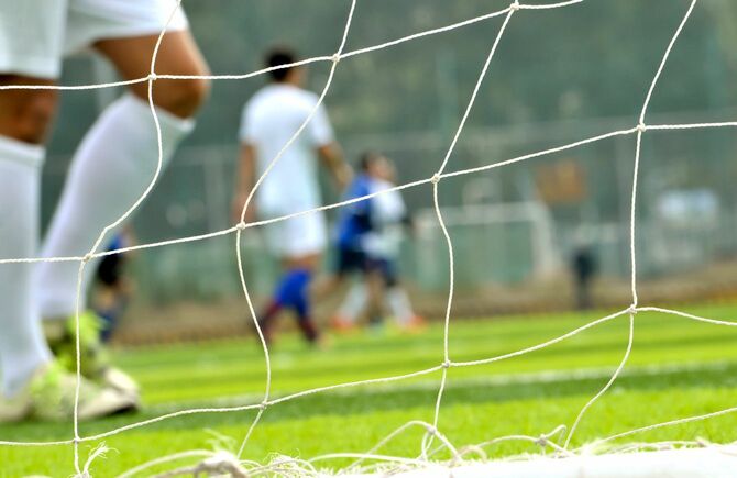 ゴールネット越しのサッカーのフィールド