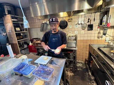厨房で作業をする建部さん