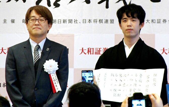 名人就位式で推戴状を手にする藤井聡太七冠（右）。左は日本将棋連盟の羽生善治会長