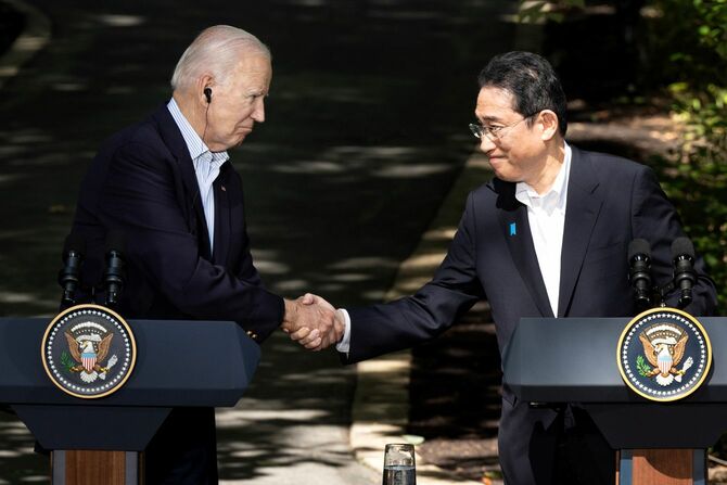 日米首脳会談、日米韓首脳会談の後の共同記者会見で握手する岸田文雄首相（右）とバイデン大統領（アメリカ・ワシントン近郊のキャンプデービッド山荘）