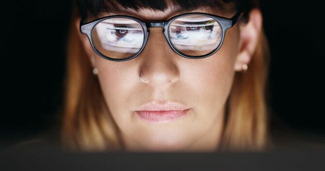 暗い部屋でパソコンを使用してる女性