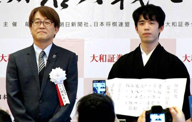 名人就位式で推戴状を手にする藤井聡太七冠(右)。左は日本将棋連盟の羽生善治会長
