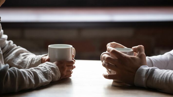 テーブルの上のコーヒーのカップを持つ女性と男性