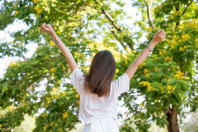 公園で伸びをする女性