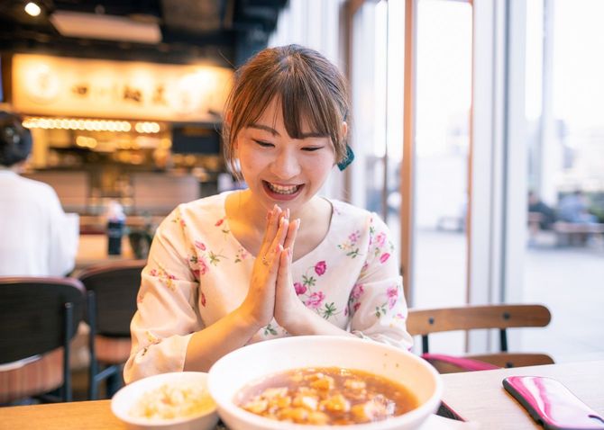 レストランで中華料理を食べる若い女性