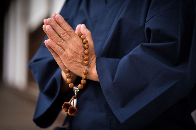 数珠を持って祈る