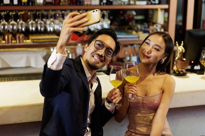 バーカウンターで写真を撮る男女