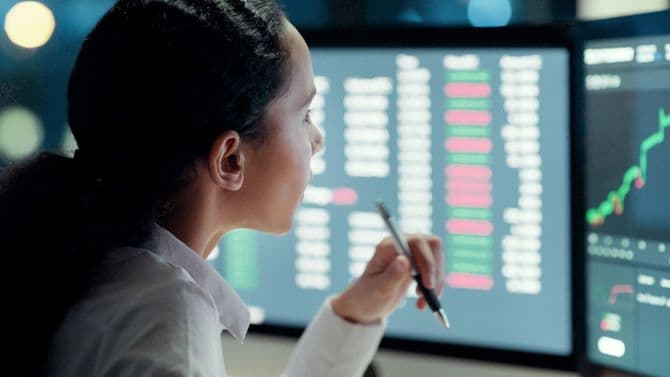 トレーダーの女性がチャートを見つめている