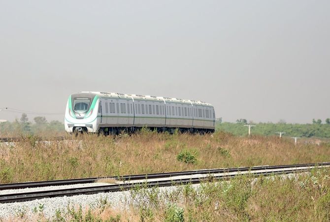 2022年12月5日、ナイジェリアのアブジャにある駅の近くの線路を走る列車。