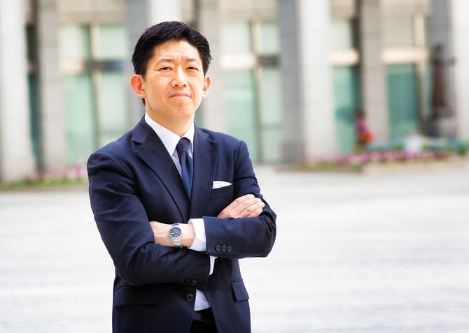 屋外で腕を組む、自信に満ちた日本人ビジネスマン