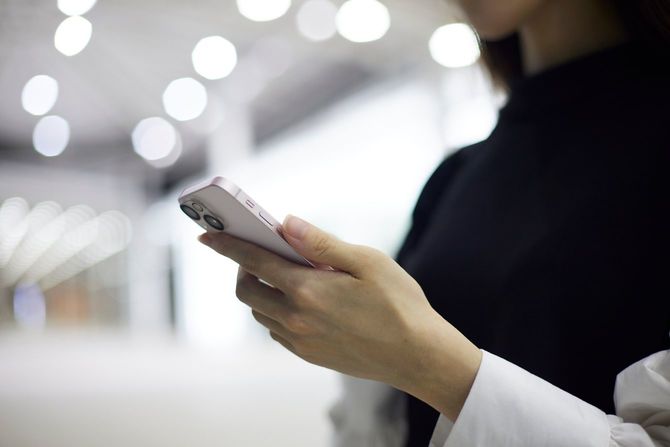 スマートフォンを使用する女性の手元