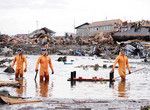 津波で一帯が破壊され、200人以上の遺体が見つかった仙台市若林区荒浜にて。右端の隊員のもつボートに遺体を乗せる。