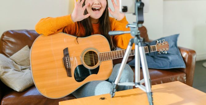 アコースティックギターを持つ女性がライブストリーミング中