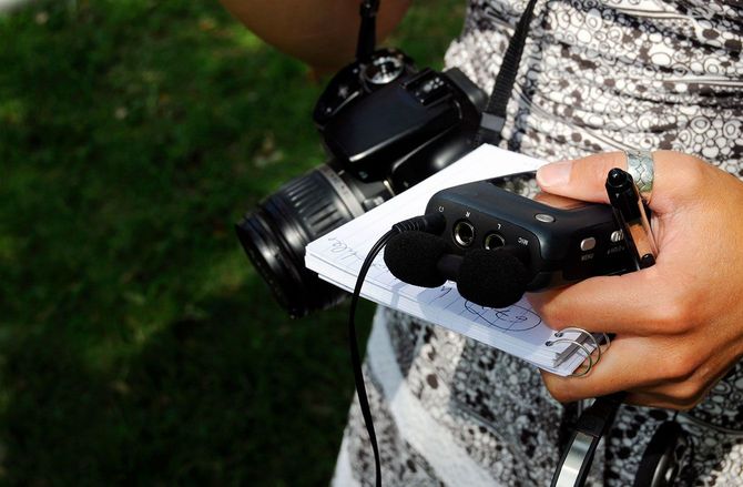 カメラや筆記具などを持つジャーナリスト