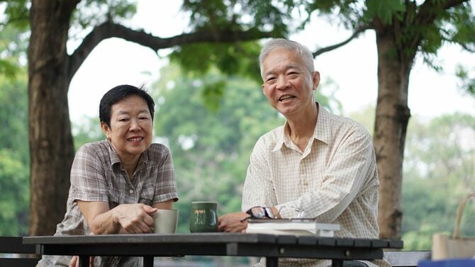 公園でコーヒーを飲むシニア夫婦