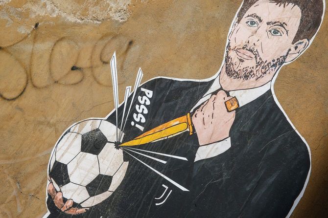 2021年4月21日、イタリア・ローマのビルの壁に、ストリートアーティストLaika MCMLIVが描いた壁画には、ユベントスの会長がナイフでサッカーボールを刺している様子が描かれている。
