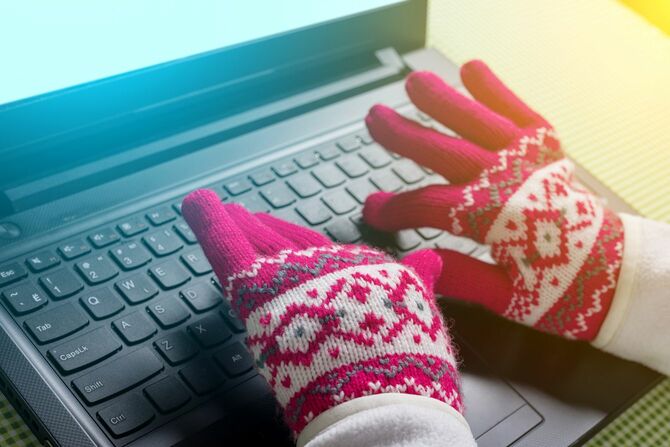 手袋をしてノートパソコンを使用する女性の手元