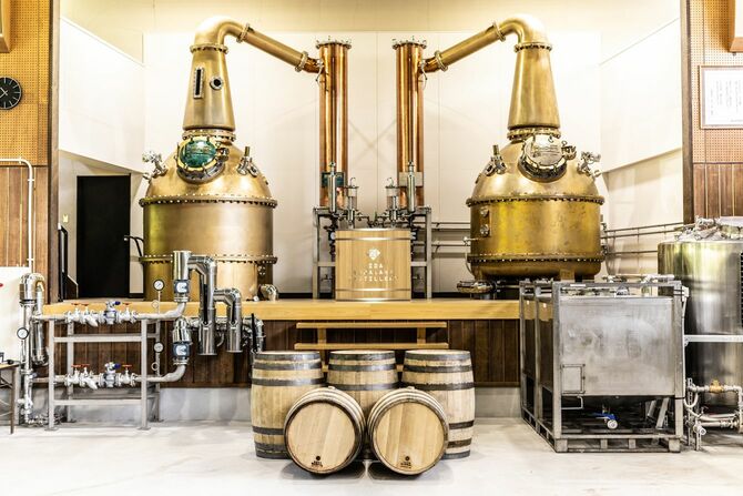 体育館のステージに設置された世界初の国産鋳造製蒸留器「ZEMON II」。