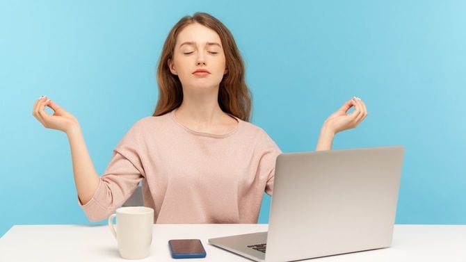 休憩中に自席にてムドラのポーズで心の平穏を取り戻す女性
