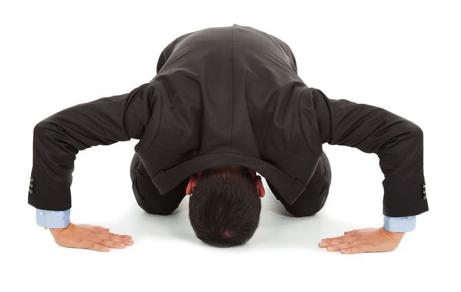 日本のビジネスマンがひざまずいて詫びする