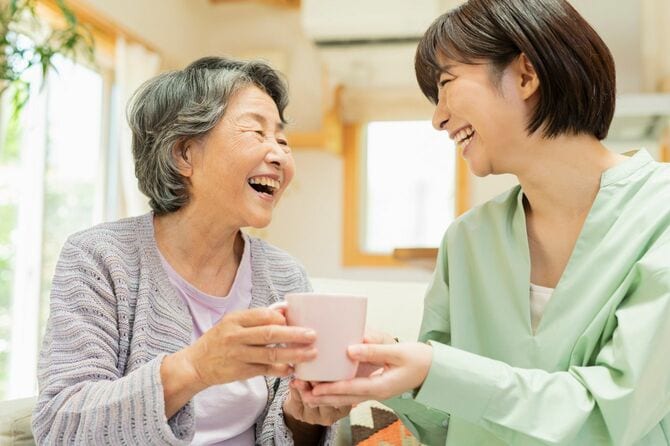 笑顔でお茶を飲む老母親と子