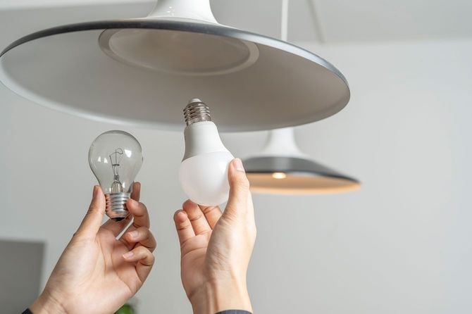 古い電球からLED電球に交換する人の手元