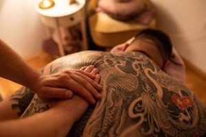 マッサージを受ける背中に入れ墨のある男性