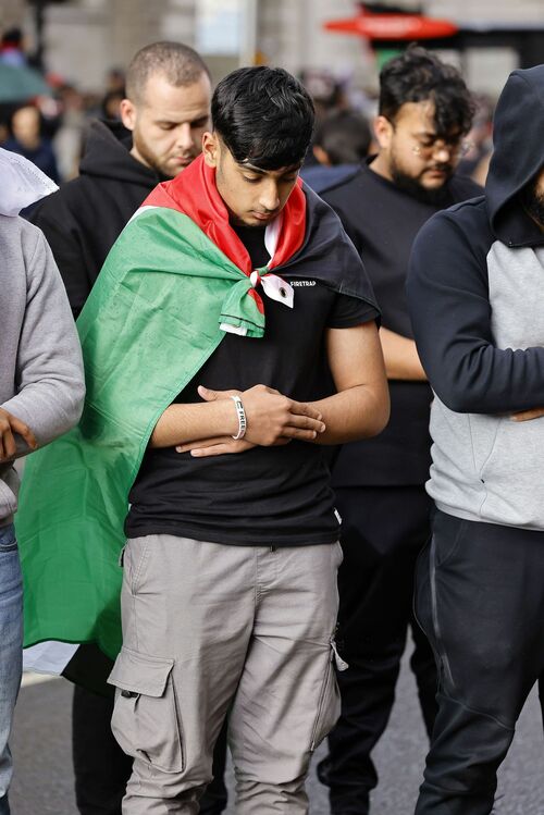 ダウニング街近くの路上で祈る親パレスチナのデモ隊の縦長ショット